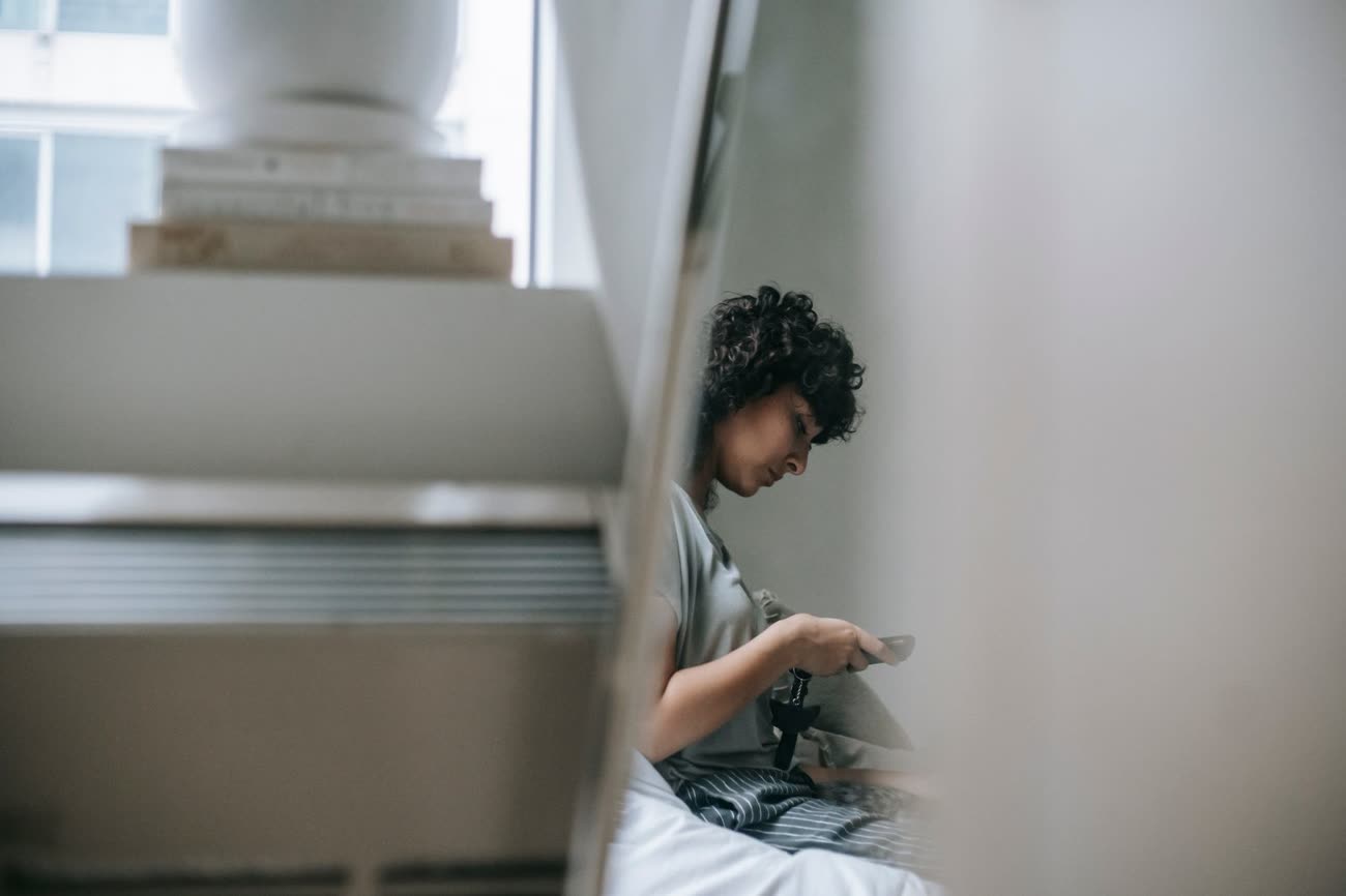 A person reading on a phone by a window